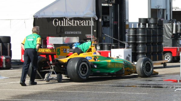 De Team Australia monteurs rijden de wagen van Will Power terug naar het team